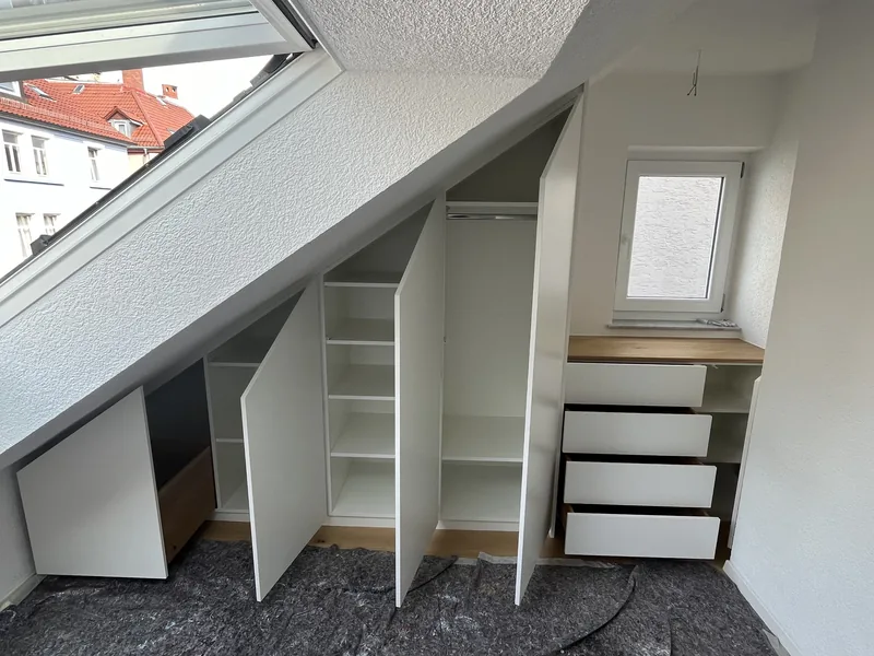 Einbauschrank unter Dachschräge mit geöffneten Türen