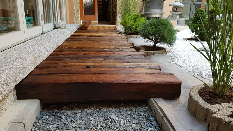 Massiver Holzsteg in einer gestalteten Gartenanlage