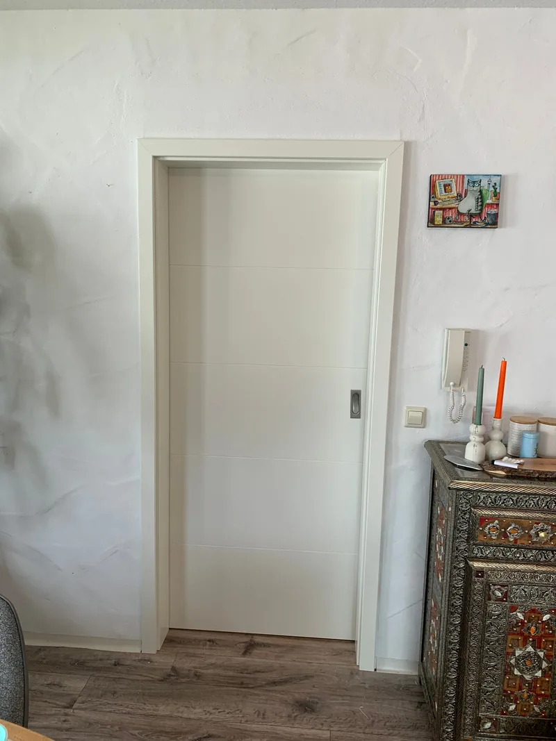 Neue weiße Schiebetür mit dezenter Linienstruktur
